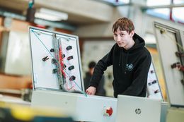 Leerling elektriciteit oefent met schakelkast.