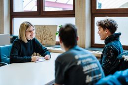 Twee leerlingen in gesprek met de leerkracht