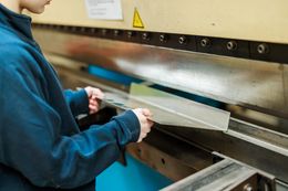 Leerling derde graad lassen-constructie plooit metaal in de werkplaats