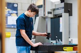 Leerling bedient machine in werkplaats mechanische vormgevingstechnieken