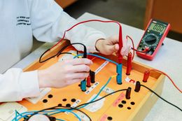 Leerling oefent tijdens de les elektriciteit.